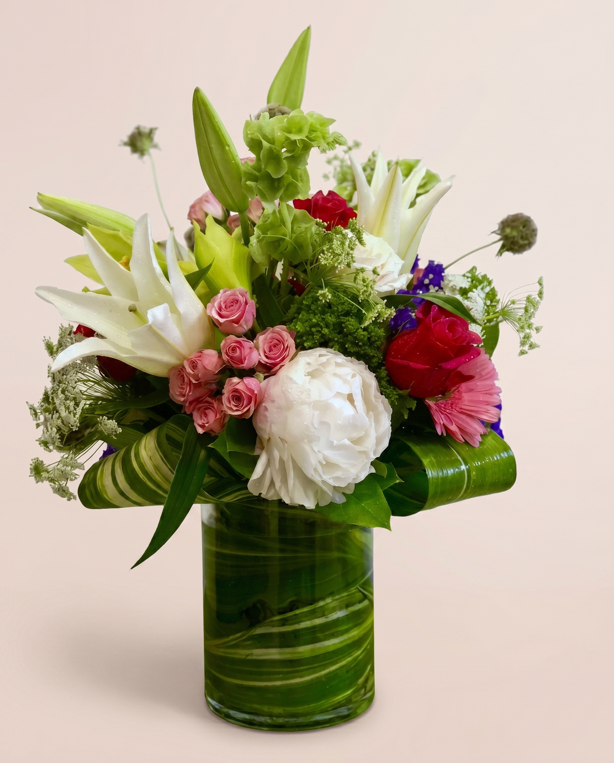 Emerald Garden Bouquet — white blooms and rosy accents with lush foliage in a glass vase