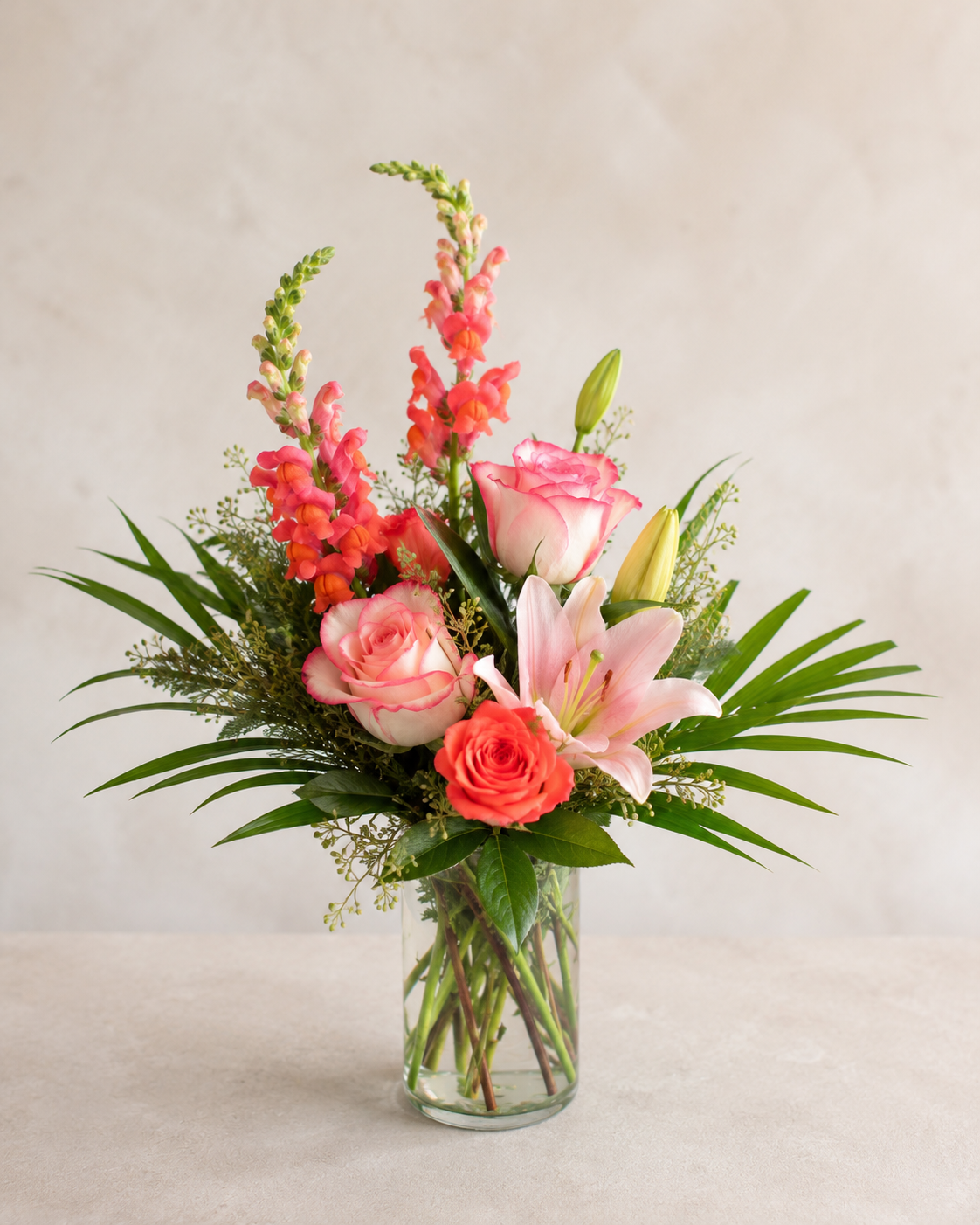 Standard Coral Bloom Bouquet with pink roses, orange rose, pink lily, coral snapdragons and greenery