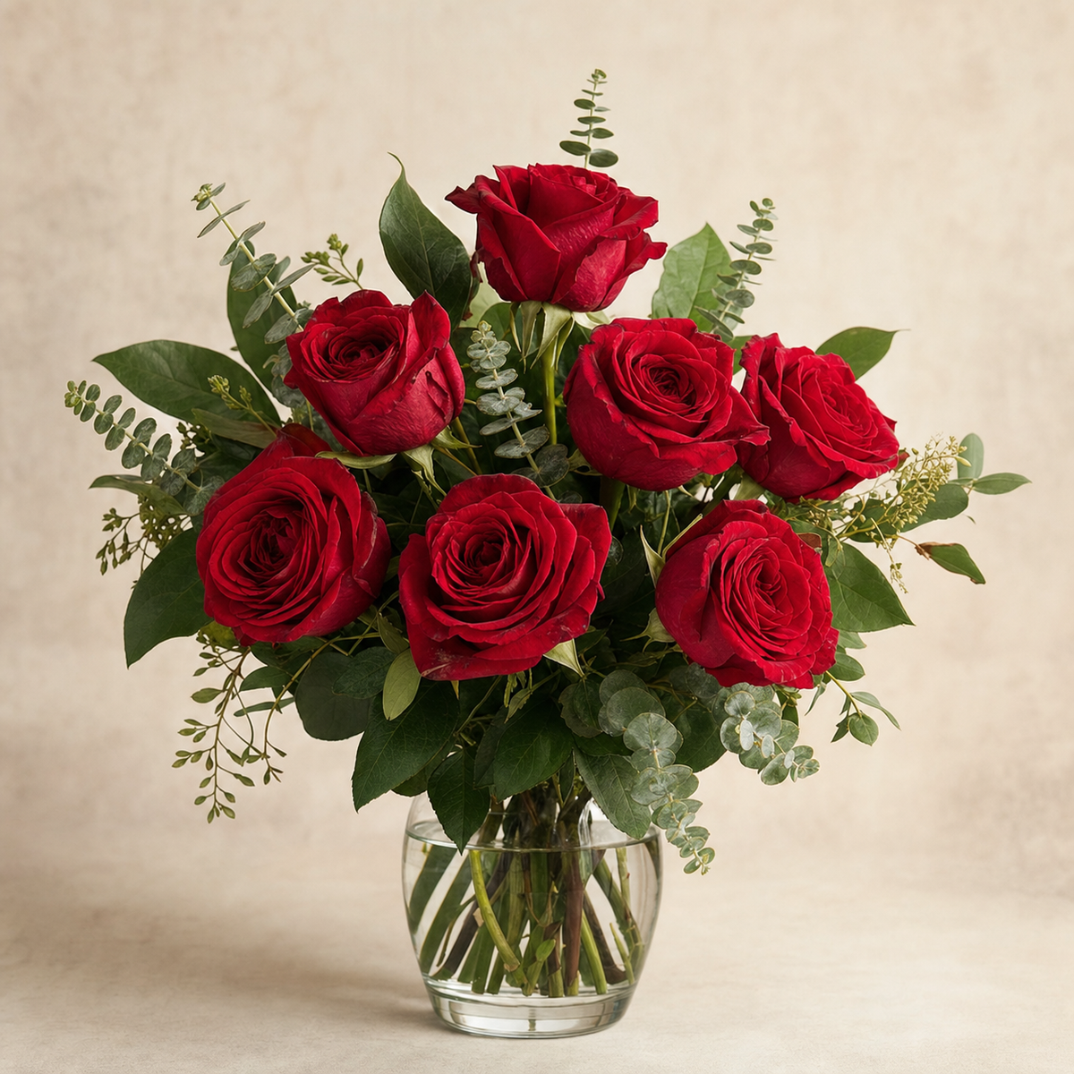 Divine Devotion Standard – compact arrangement of red roses with green eucalyptus and lemon leaf in a clear glass vase, smaller lighter version