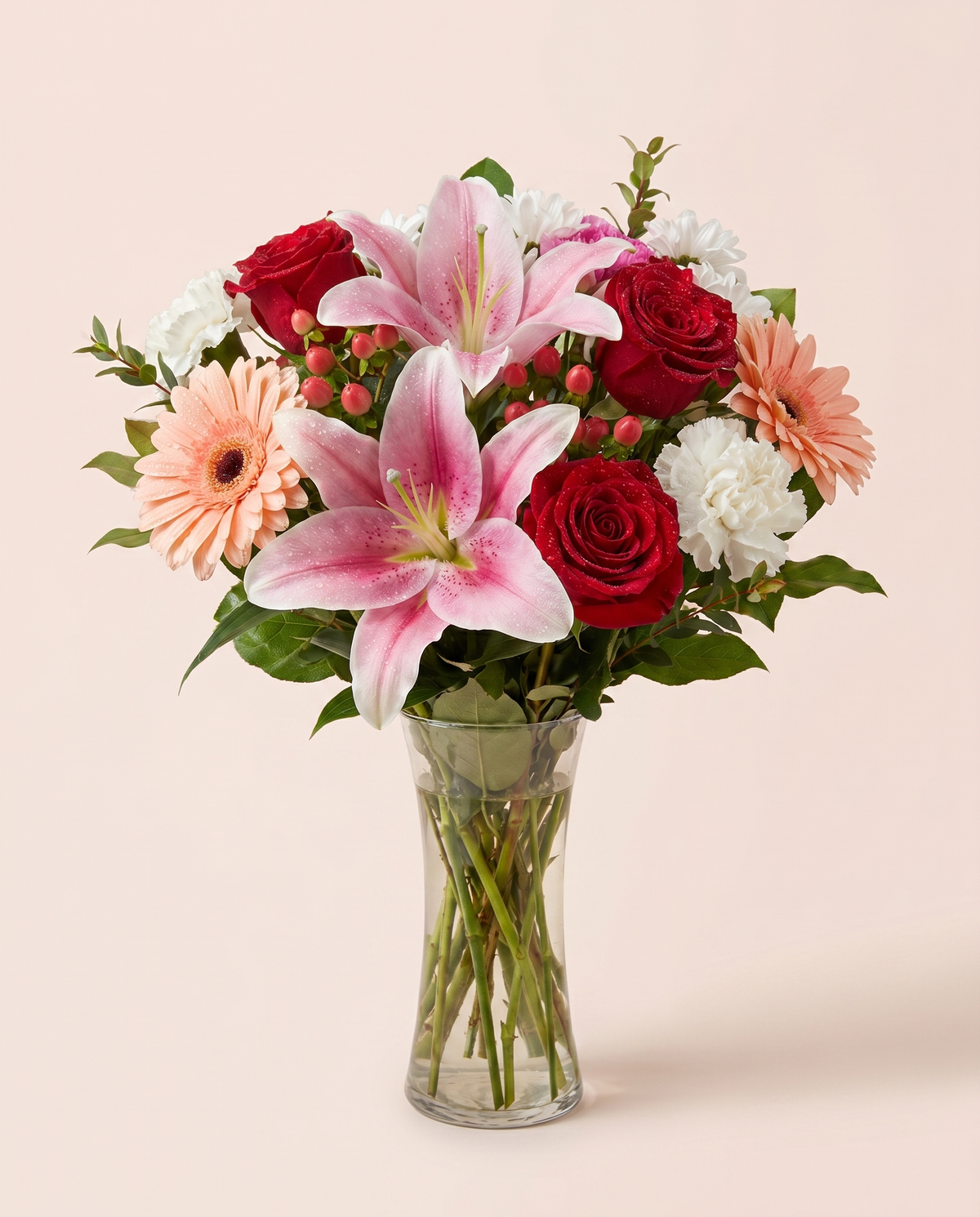 Rosé Daydream Bouquet — pink lilies, gerbera daisies, and red roses in a glass vase
