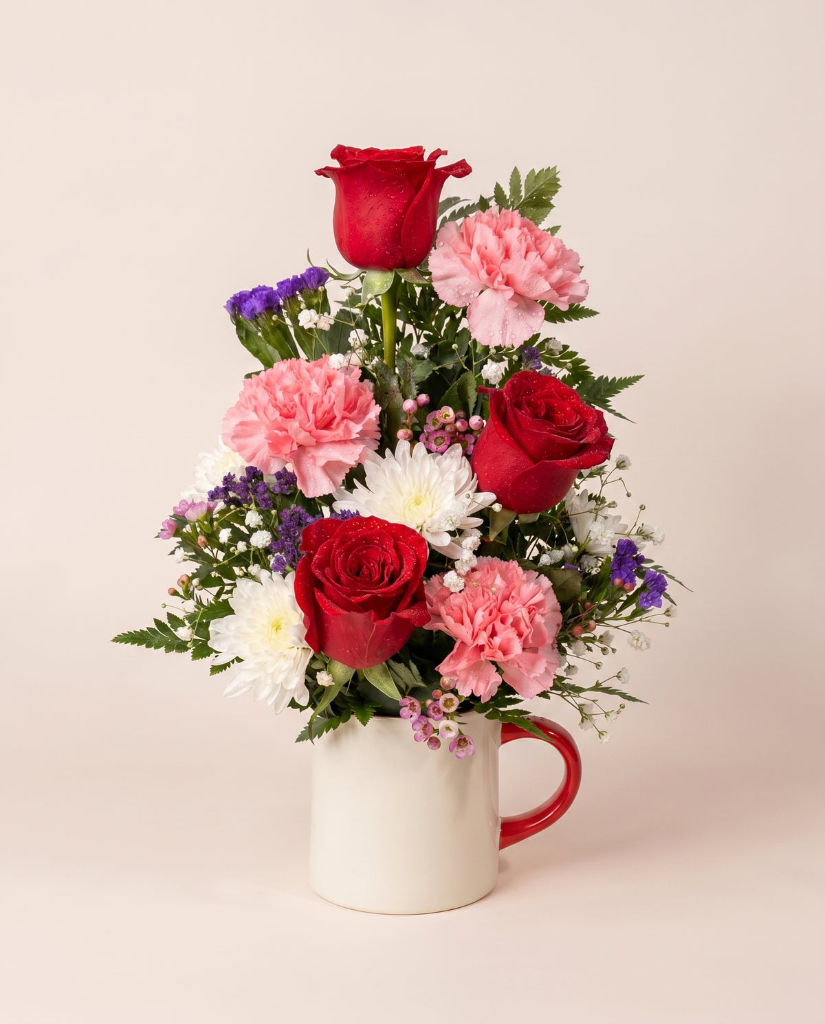 Cup of Love Bouquet — red roses, pink carnations, and white daisies in a ceramic mug