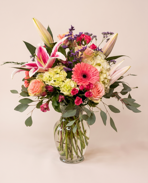 Blush Garden Bouquet — pink lilies, coral roses, and gerbera daisies in a glass vase
