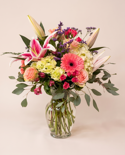 Blush Garden Bouquet — pink lilies, coral roses, and gerbera daisies in a glass vase